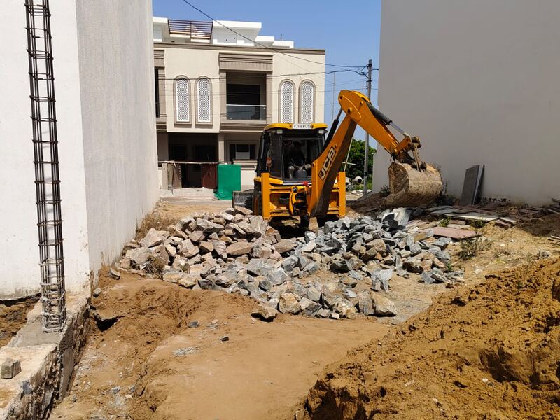 Excavator working through rock and spoil during site development